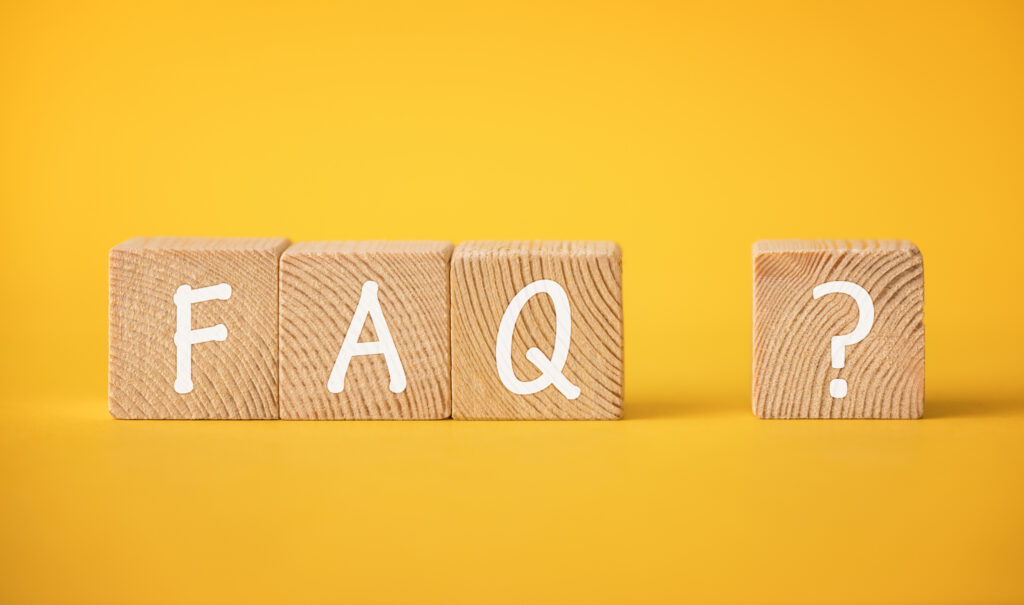 Wooden letters spelling out 'FAQ' against an orange background. FAQs for Lighting Installation.